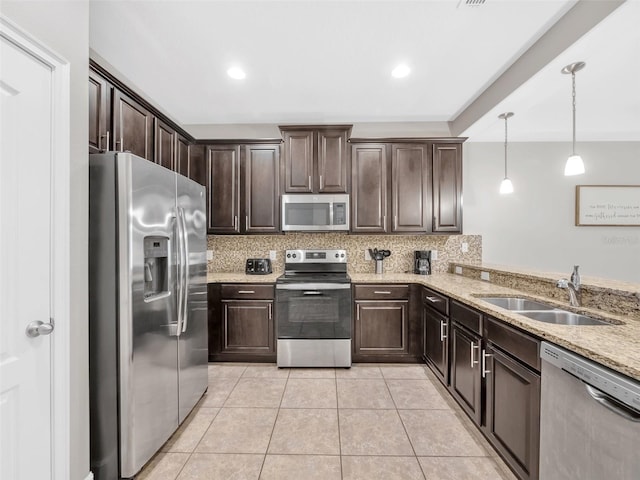 8215 Roseville Blvd, Davenport, FL 33896 - kitchen featuring appliances with stainless steel finishes, a sink, dark brown cabinetry, tasteful backsplash, and recessed lighting