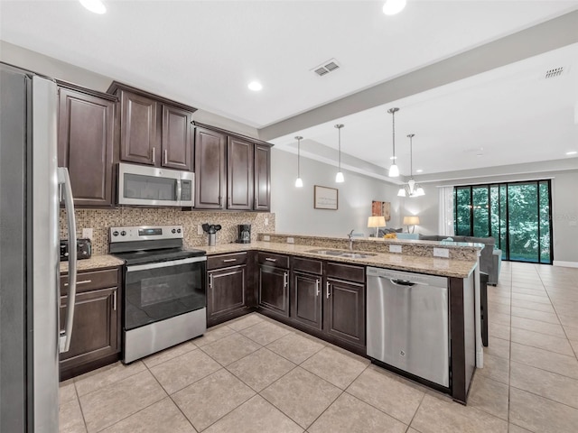 8215 Roseville Blvd, Davenport, FL 33896 - kitchen with appliances with stainless steel finishes, a sink, dark brown cabinetry, open floor plan, and light tile patterned floors