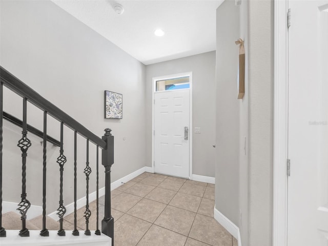 8215 Roseville Blvd, Davenport, FL 33896 - foyer entrance with light tile patterned floors, baseboards, and stairway