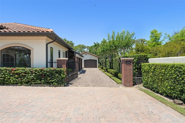 1741 Palmer Ave, Winter Park, FL 32789 - view of side of property with a gate, a tile roof, stucco siding, driveway, and brick siding