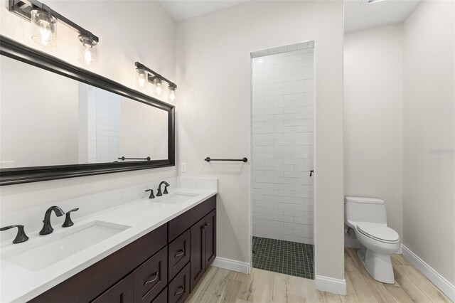 1741 Palmer Ave, Winter Park, FL 32789 - bathroom with wood finished floors, toilet, a tile shower, and double vanity