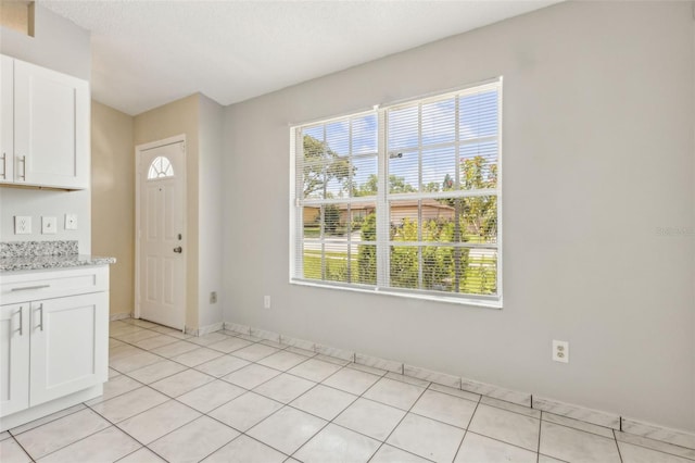 896 Satin Leaf Cir, Ocoee, FL 34761 - unfurnished dining area with light tile patterned floors and baseboards