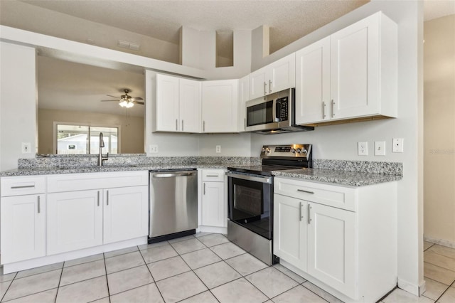 896 Satin Leaf Cir, Ocoee, FL 34761 - kitchen with appliances with stainless steel finishes, a sink, white cabinets, light tile patterned floors, and ceiling fan