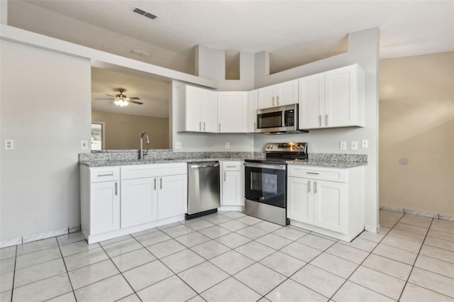 896 Satin Leaf Cir, Ocoee, FL 34761 - kitchen with stainless steel appliances, a sink, a ceiling fan, white cabinetry, and light stone countertops