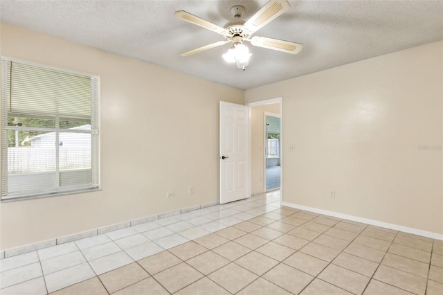 896 Satin Leaf Cir, Ocoee, FL 34761 - unfurnished room featuring light tile patterned flooring, ceiling fan, baseboards, and a textured ceiling