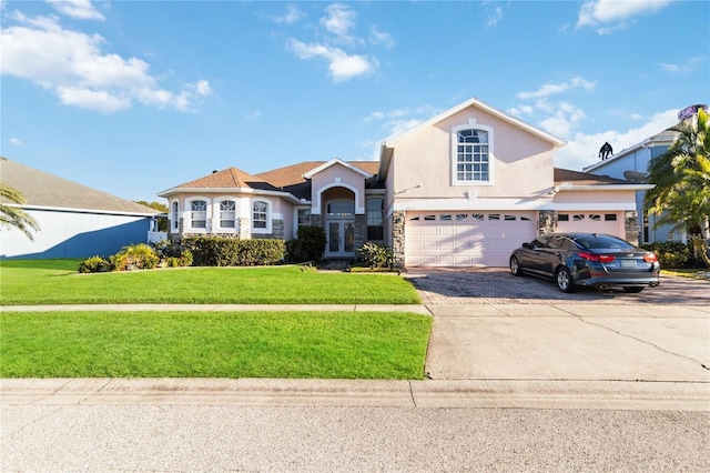 10642 Cloudview Dr, Orlando, FL 32825 - view of front facade featuring a front lawn, stucco siding, driveway, stone siding, and an attached garage
