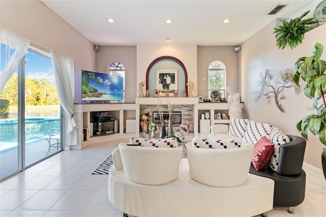 10642 Cloudview Dr, Orlando, FL 32825 - tiled living room featuring recessed lighting, plenty of natural light, and a glass covered fireplace