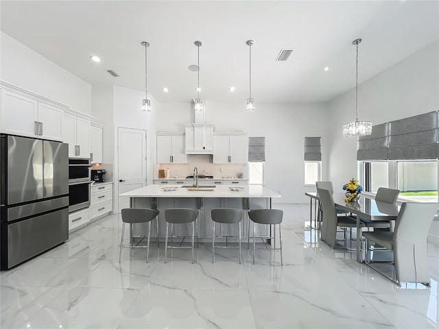 601 Green Briar Blvd, Altamonte Springs, FL 32714 - kitchen with stainless steel appliances, a kitchen bar, light countertops, a chandelier, and white cabinets