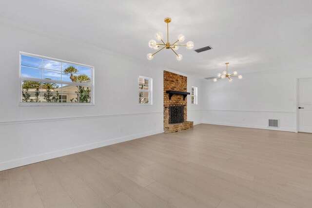 2460 Worthington Rd, Maitland, FL 32751 - unfurnished living room with a chandelier, plenty of natural light, light wood-style floors, a brick fireplace, and ornamental molding
