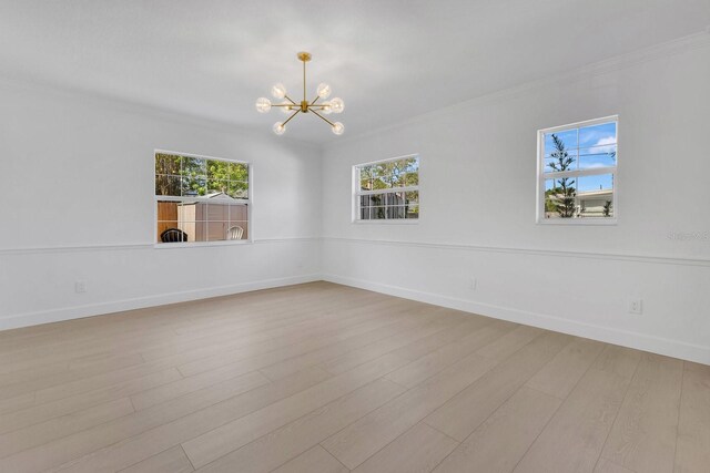 2460 Worthington Rd, Maitland, FL 32751 - empty room featuring crown molding, a chandelier, baseboards, and wood finished floors