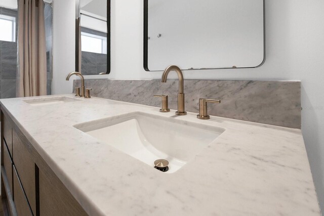 2460 Worthington Rd, Maitland, FL 32751 - bathroom featuring healthy amount of natural light, double vanity, and backsplash