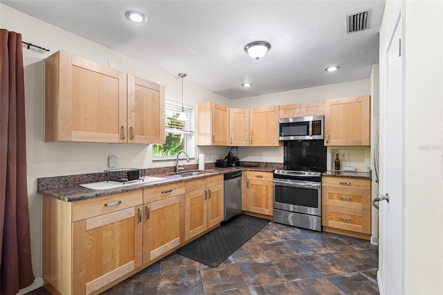 2922 SW 68th Ln, Gainesville, FL 32608 - kitchen with appliances with stainless steel finishes, light brown cabinets, stone finish flooring, dark stone countertops, and hanging light fixtures