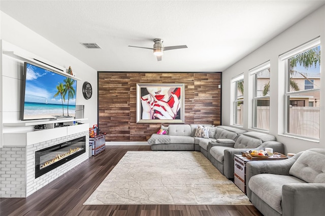 14095 Tropical Kingbird Way, Riverview, FL 33579 - living room with a ceiling fan, wood finished floors, a glass covered fireplace, and an accent wall
