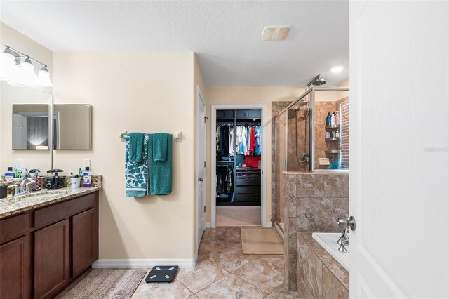 14095 Tropical Kingbird Way, Riverview, FL 33579 - bathroom with vanity, a shower stall, a bath, a spacious closet, and baseboards