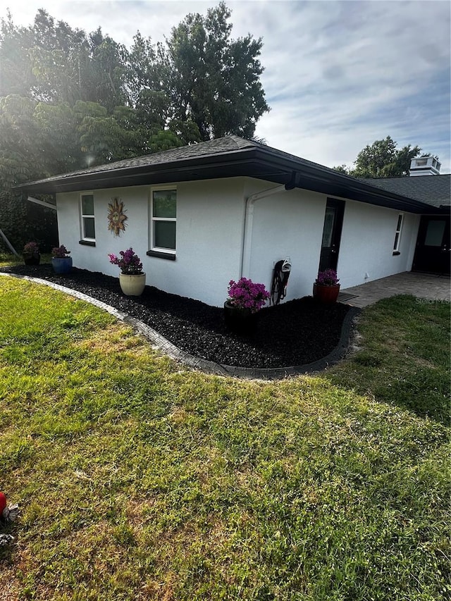 37951 Washington Loop Rd, Punta Gorda, FL 33982 - view of side of home featuring stucco siding and a lawn