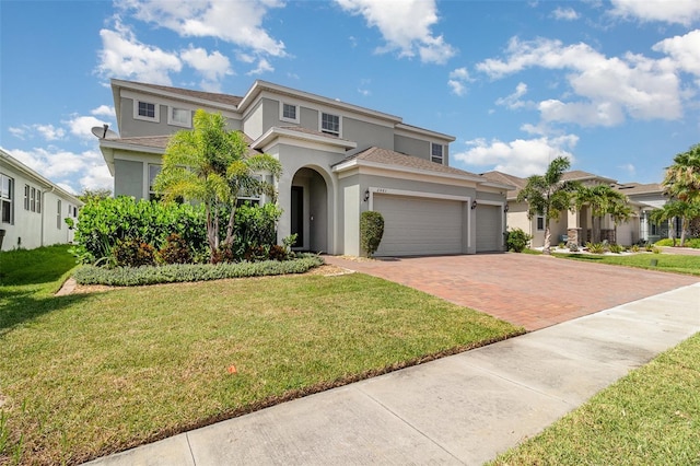 2061 Rush Bay Way, Orlando, FL 32824 - view of front of home featuring stucco siding, decorative driveway, a garage, a front lawn, and a residential view