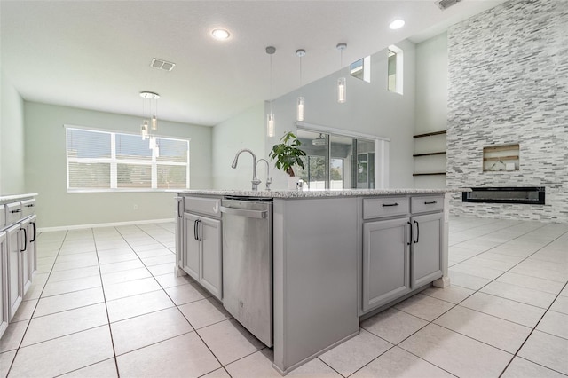 2061 Rush Bay Way, Orlando, FL 32824 - kitchen with stainless steel dishwasher, gray cabinetry, light tile patterned floors, a tile fireplace, and recessed lighting