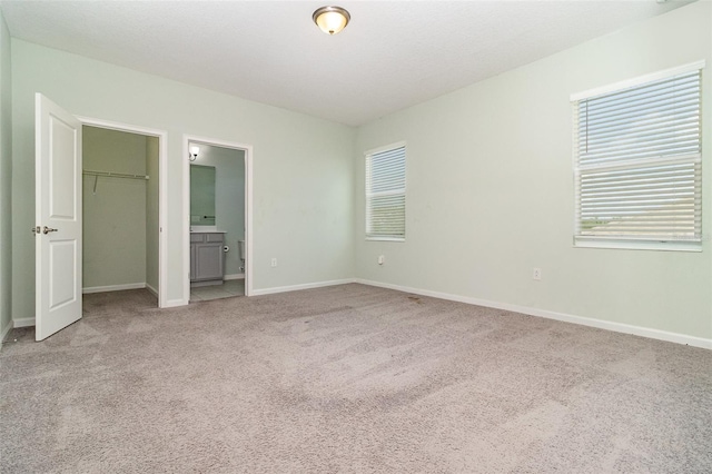 2061 Rush Bay Way, Orlando, FL 32824 - unfurnished bedroom featuring light colored carpet, multiple windows, a walk in closet, and a closet