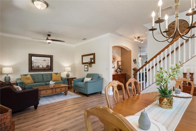 402 S Lake Victoria Cir, Deland, FL 32724 - dining area featuring light wood-type flooring, ornamental molding, a textured ceiling, arched walkways, and stairs