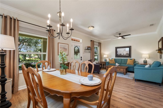 402 S Lake Victoria Cir, Deland, FL 32724 - dining room with light wood-style flooring, healthy amount of natural light, a textured ceiling, crown molding, and a chandelier