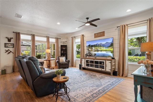402 S Lake Victoria Cir, Deland, FL 32724 - living area featuring crown molding, healthy amount of natural light, wood finished floors, a ceiling fan, and a textured ceiling