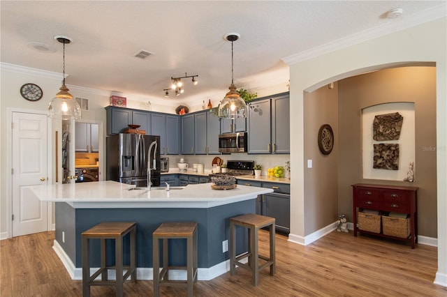 402 S Lake Victoria Cir, Deland, FL 32724 - kitchen featuring stainless steel appliances, a sink, light countertops, a kitchen bar, and ornamental molding