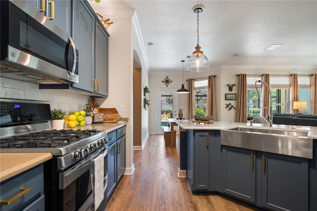 402 S Lake Victoria Cir, Deland, FL 32724 - kitchen with stainless steel appliances, blue cabinetry, crown molding, light countertops, and backsplash