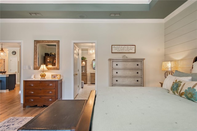 402 S Lake Victoria Cir, Deland, FL 32724 - bedroom featuring ornamental molding, light wood-style flooring, ensuite bath, and a chandelier