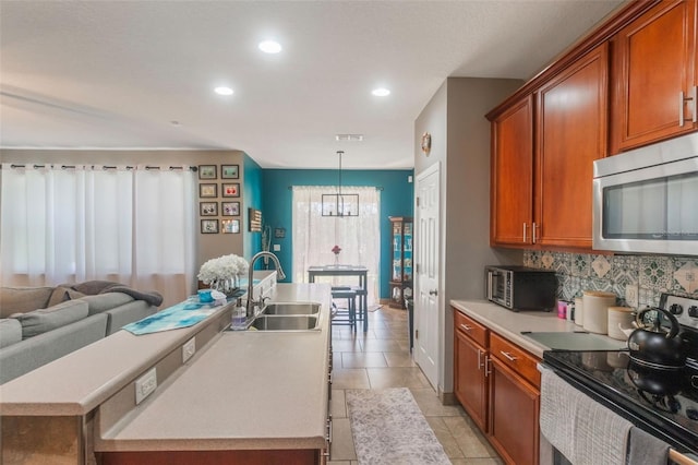 2619 Breezy Meadow Rd, Apopka, FL 32712 - kitchen with stainless steel microwave, a sink, range with electric stovetop, tasteful backsplash, and recessed lighting