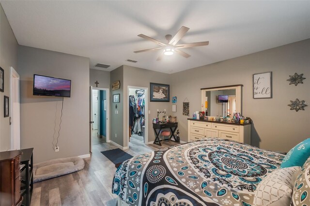 2619 Breezy Meadow Rd, Apopka, FL 32712 - bedroom with light wood-type flooring, a walk in closet, a ceiling fan, a closet, and baseboards