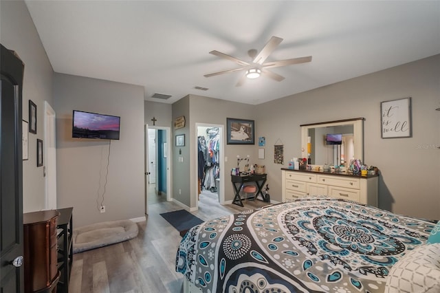 2619 Breezy Meadow Rd, Apopka, FL 32712 - bedroom with wood finished floors, a walk in closet, ceiling fan, baseboards, and a closet