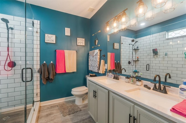 2619 Breezy Meadow Rd, Apopka, FL 32712 - full bath with wood finished floors, a shower stall, toilet, double vanity, and baseboards
