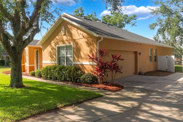 2619 Breezy Meadow Rd, Apopka, FL 32712 - view of property exterior featuring an attached garage, stucco siding, driveway, and a lawn