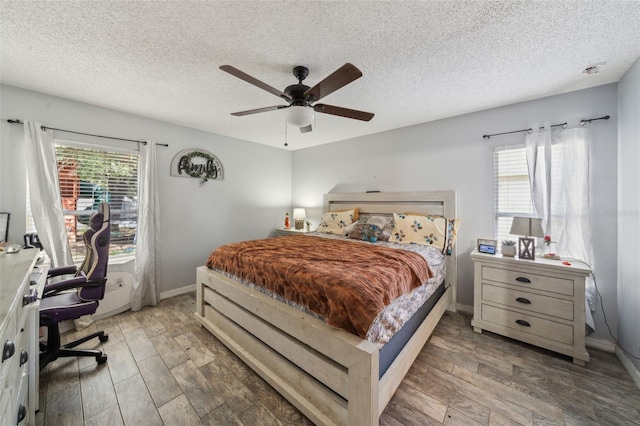 2354 Barons Ct, Tavares, FL 32778 - bedroom with wood finished floors, a desk, a textured ceiling, a ceiling fan, and baseboards