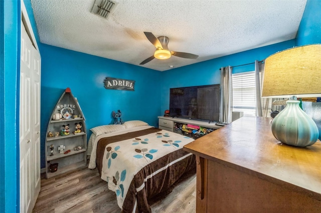 2354 Barons Ct, Tavares, FL 32778 - bedroom with a textured ceiling, wood finished floors, a closet, and ceiling fan