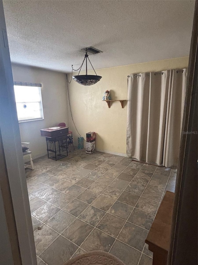 977 E Normandy Blvd, Deltona, FL 32725 - unfurnished dining area with a textured ceiling and dark stone finish floors