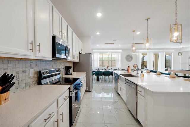 3860 Sonoma Blvd, Kissimmee, FL 34741 - kitchen featuring stainless steel appliances, decorative backsplash, white cabinets, a large island, and recessed lighting