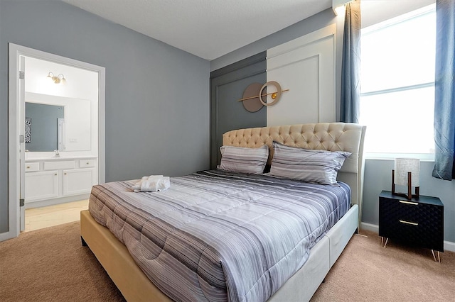 3860 Sonoma Blvd, Kissimmee, FL 34741 - bedroom featuring light colored carpet, a sink, connected bathroom, and baseboards