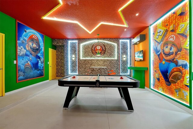 3860 Sonoma Blvd, Kissimmee, FL 34741 - recreation room featuring a textured ceiling, brick wall, and finished concrete flooring