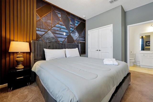 3860 Sonoma Blvd, Kissimmee, FL 34741 - carpeted bedroom featuring a closet, ensuite bathroom, and a textured ceiling