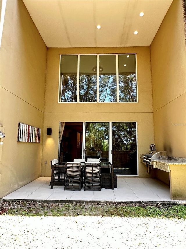 7667 Recife Dr, Kissimmee, FL 34747 - rear view of property featuring a patio area, stucco siding, and outdoor lounge area