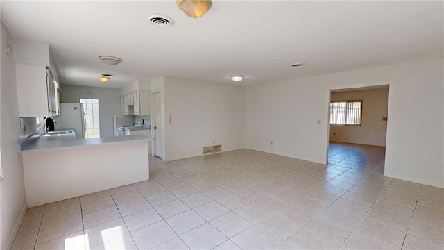 1119 Edith Dr, Daytona Beach, FL 32117 - kitchen featuring white appliances, light tile patterned floors, light countertops, white cabinets, and open floor plan