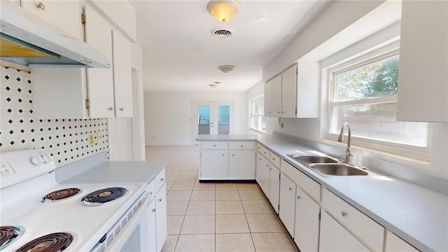 1119 Edith Dr, Daytona Beach, FL 32117 - kitchen featuring under cabinet range hood, white electric range, light countertops, light tile patterned floors, and white cabinetry