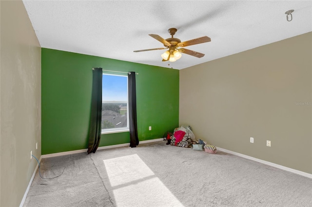 game room featuring carpet floors, a ceiling fan, a textured ceiling, and baseboards
