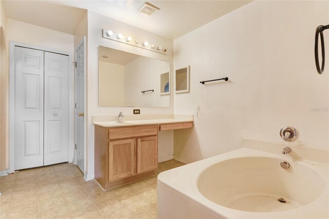 full bathroom with a closet, a bath, vanity, and baseboards