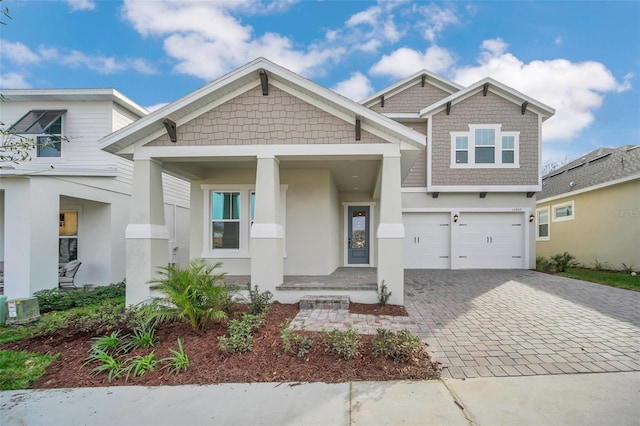 13081 Sunrise Harvest Dr, Winter Garden, FL 34787 - craftsman-style house featuring stucco siding, decorative driveway, a garage, and a porch