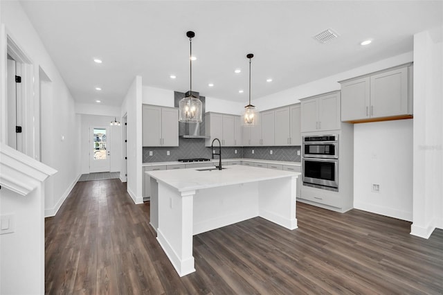13081 Sunrise Harvest Dr, Winter Garden, FL 34787 - kitchen featuring gray cabinets, light countertops, dark wood-style flooring, decorative backsplash, and double oven