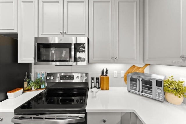 1 Riverwalk Dr Unit 303, New Smyrna Beach, FL 32169 - kitchen featuring stainless steel appliances, light countertops, and backsplash