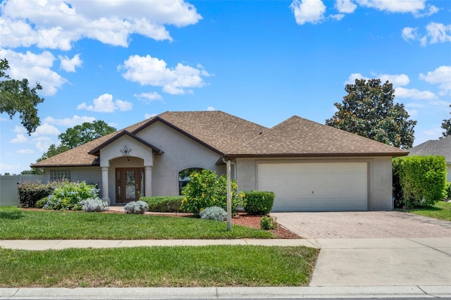 4571 Abaco Dr, Tavares, FL 32778 - view of front of home featuring stucco siding, decorative driveway, an attached garage, a front yard, and a shingled roof