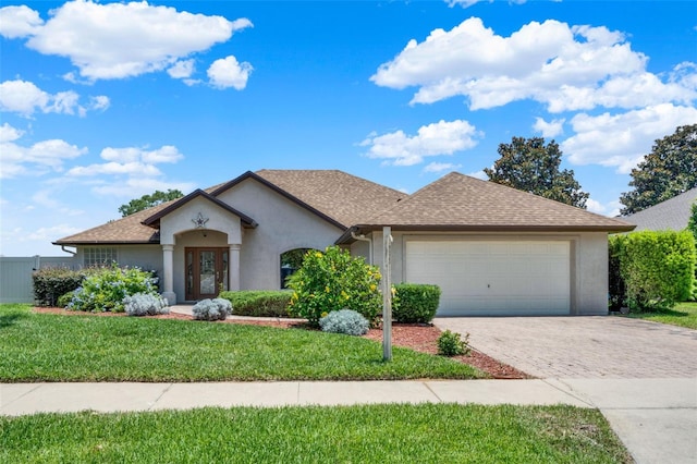 4571 Abaco Dr, Tavares, FL 32778 - view of front of house featuring stucco siding, a garage, decorative driveway, a front lawn, and roof with shingles